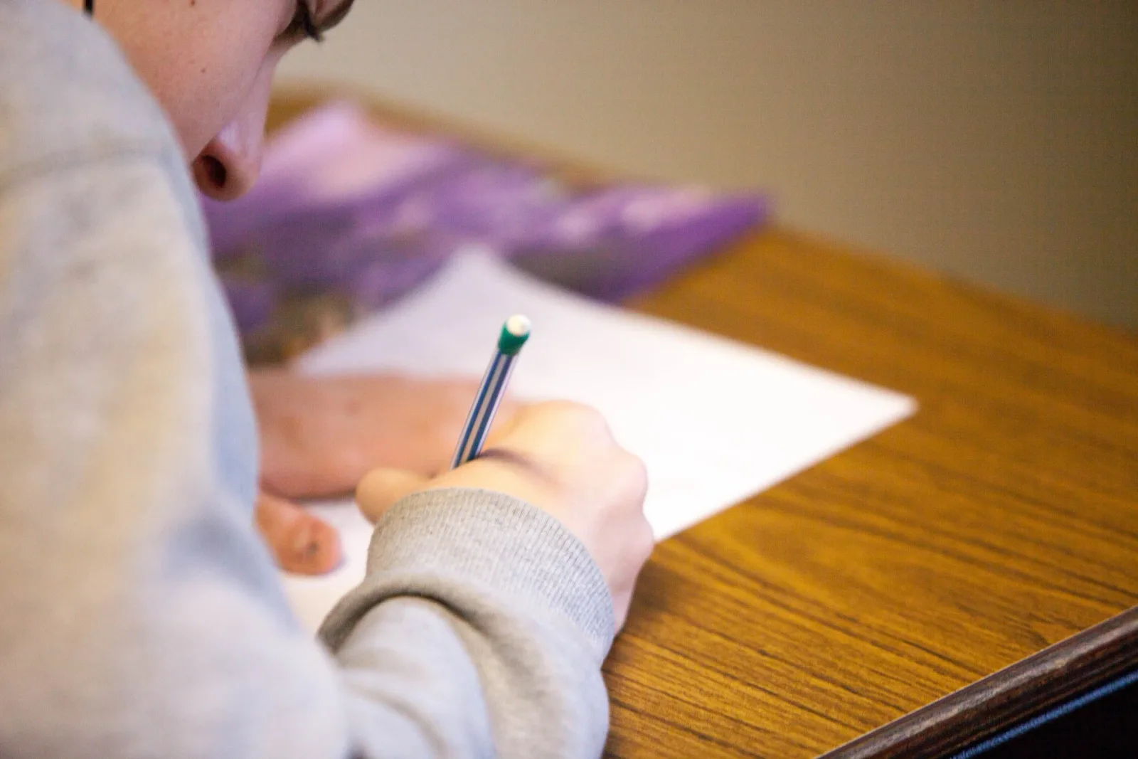 A student working through a timed practice test with pencil and paper
