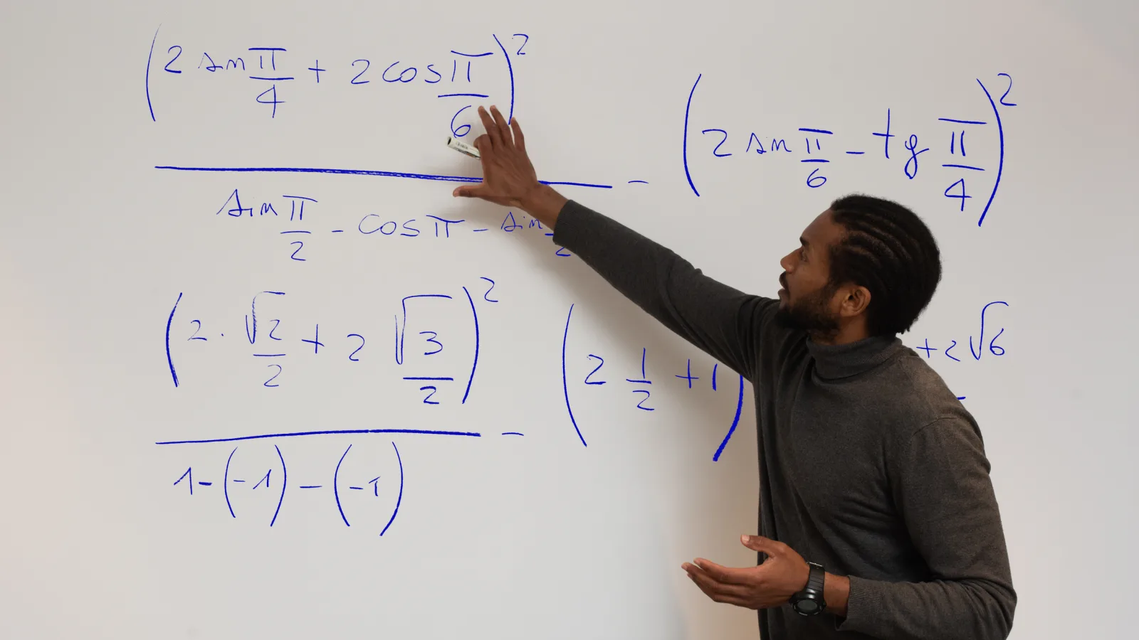 A Higher Ground Learning instructor explaining a trigonometry problem at a whiteboard