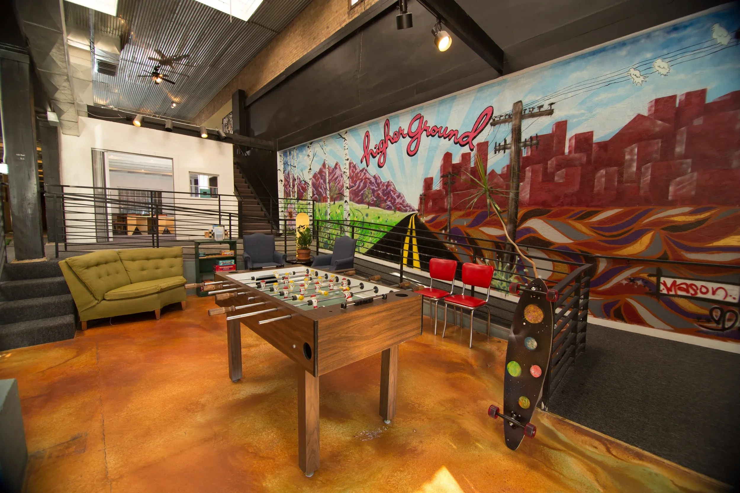 The Higher Ground Learning space in downtown Salt Lake City — mountain mural, foosball table, and mezzanine